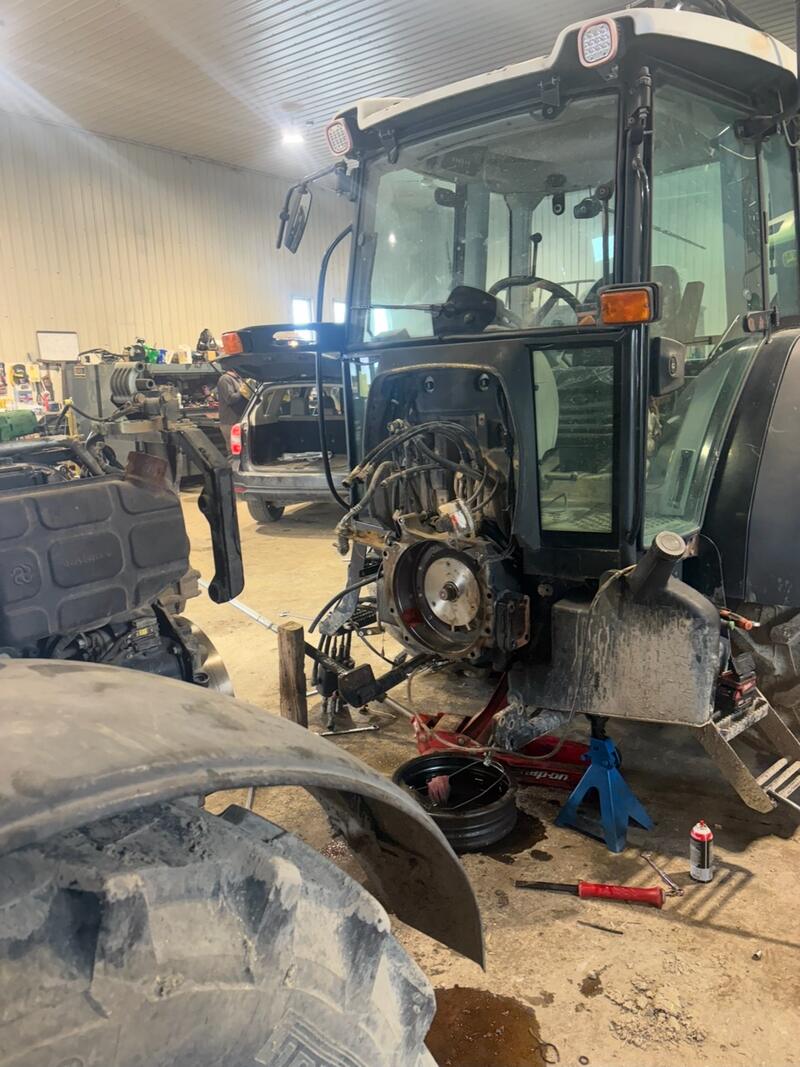 Tractor in the shop with the engine out and the cab opened up