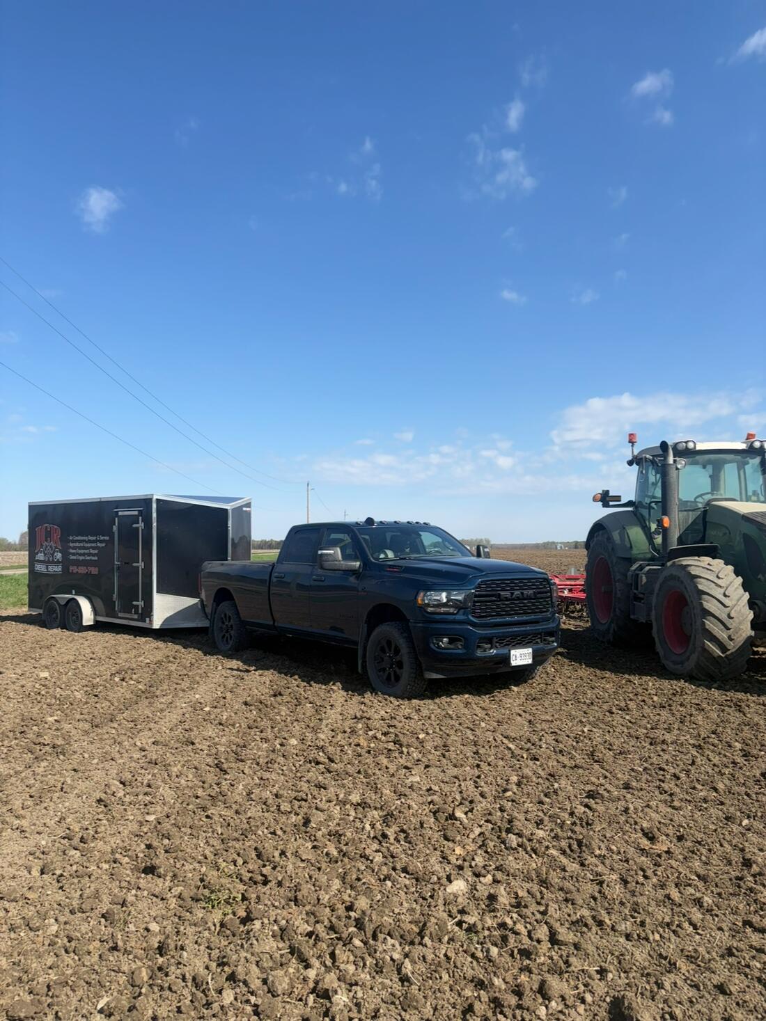 JCR truck and trailer parked in a field beside a Fendt tractor