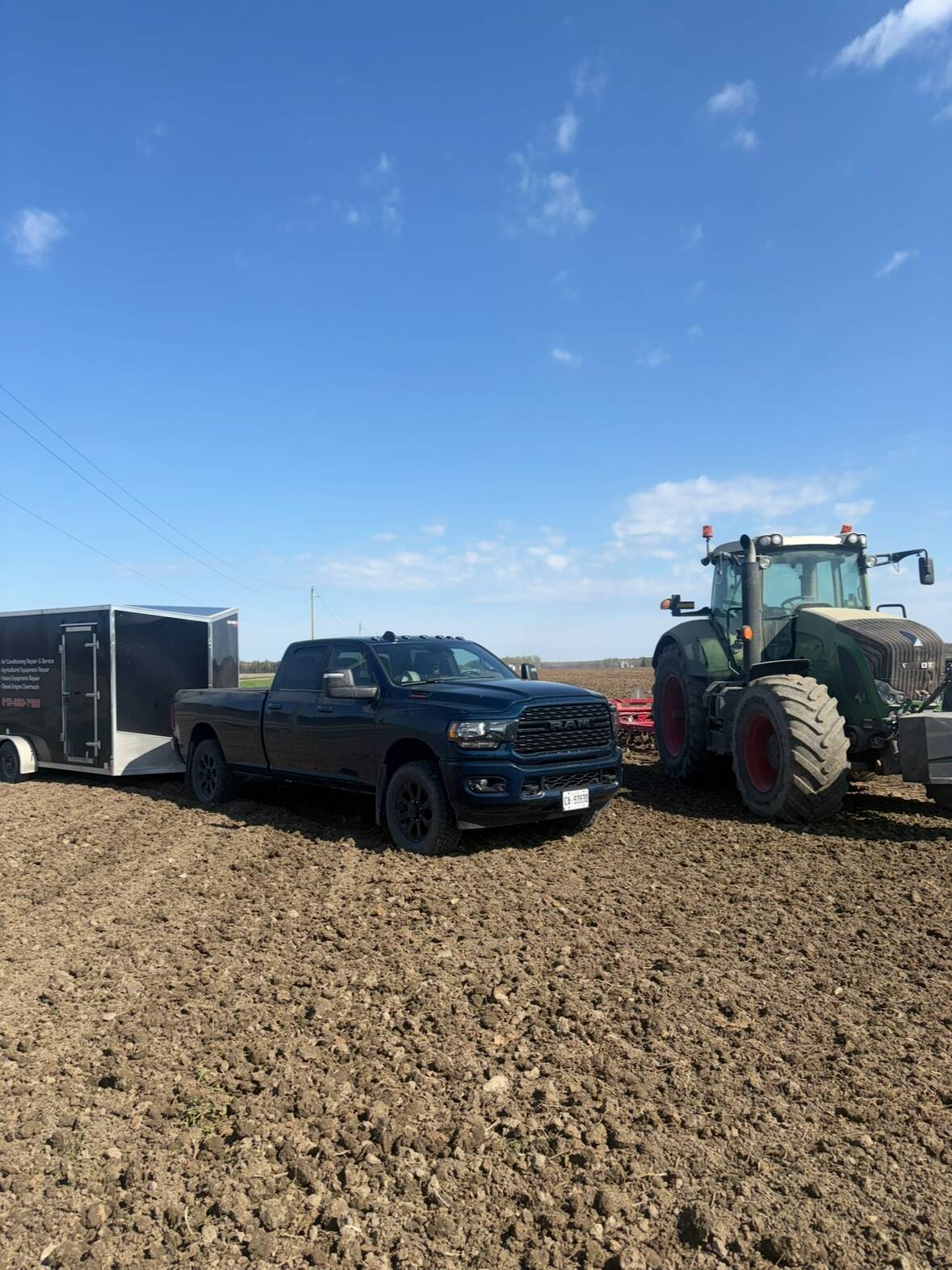 JCR service truck and trailer parked beside a Fendt tractor in a worked field