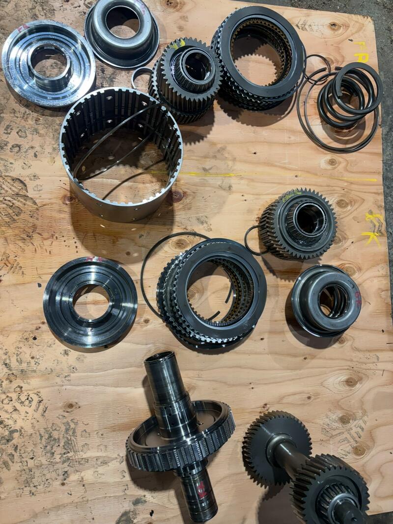 Transmission gears and clutch packs laid out on a bench