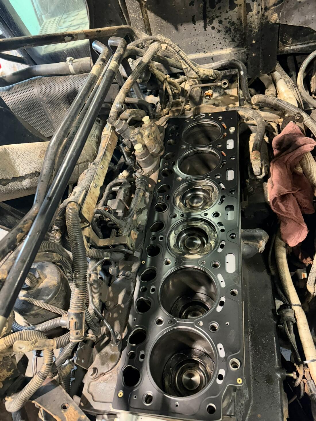 Six-cylinder diesel engine with the head off, partway through a rebuild